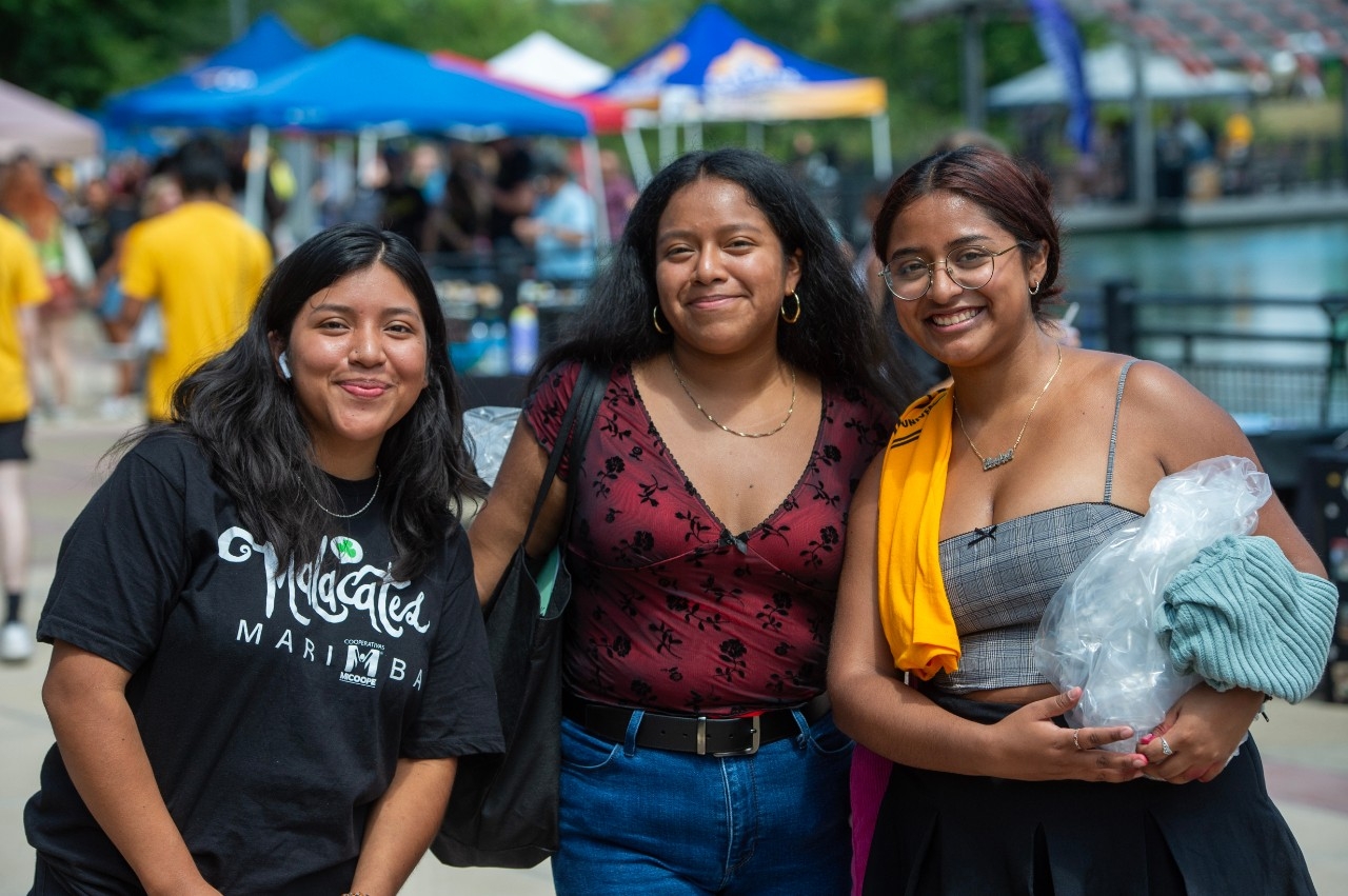 Three female students posing by Loch Norse at Victorfest