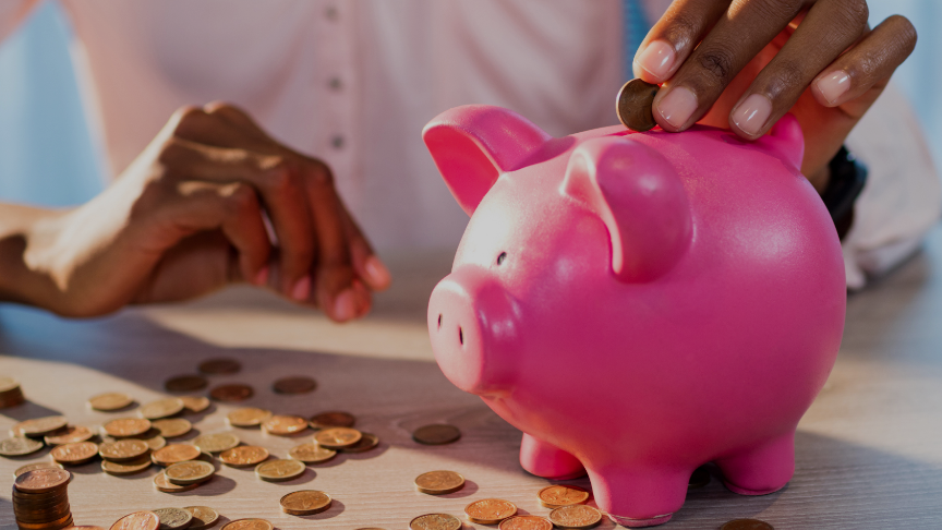 A person putting coins into a piggy bank