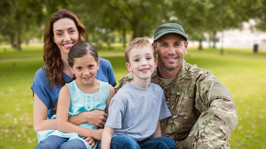 A family group picture - a man wears camouflage